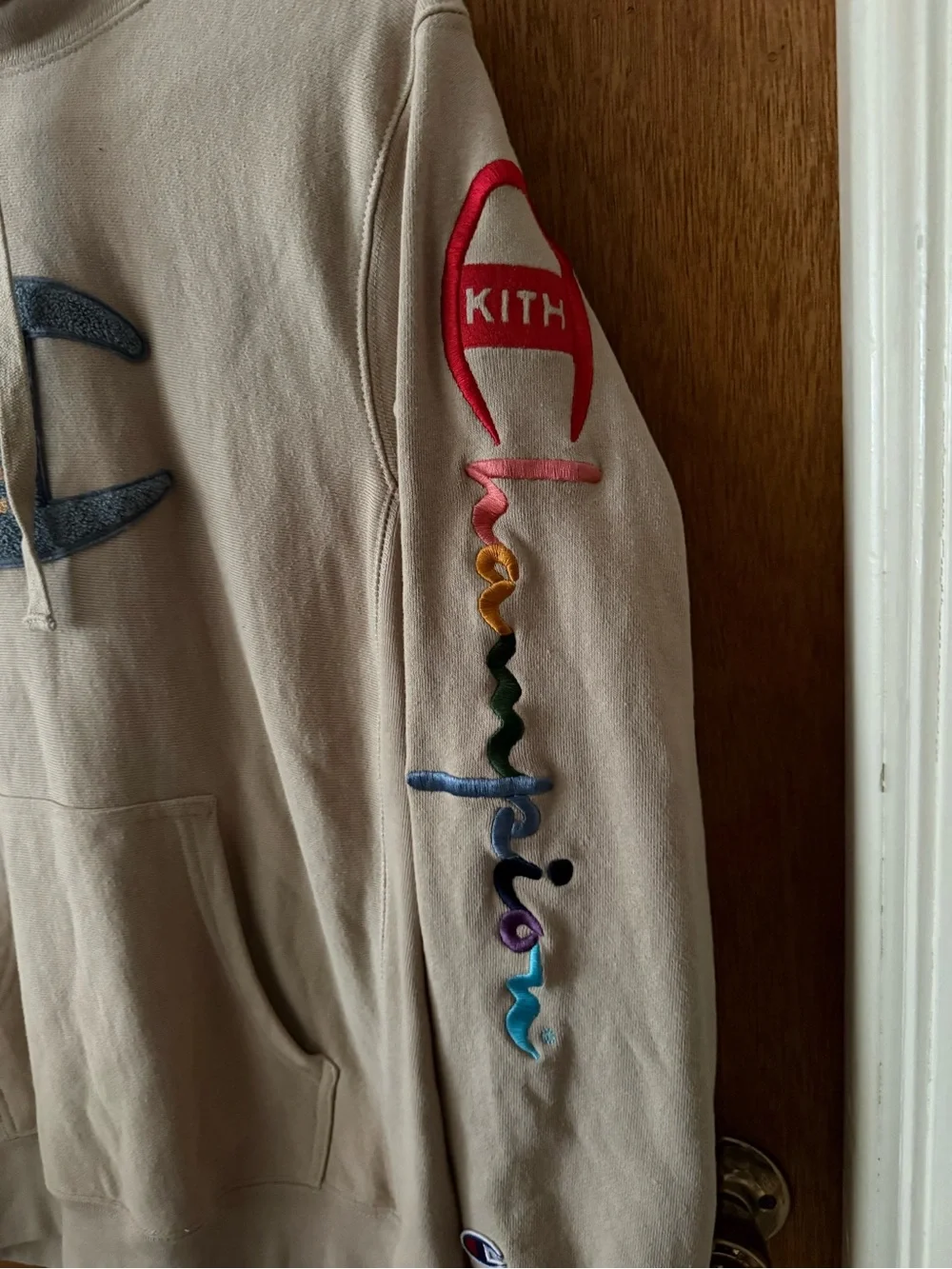 Kith and Champion Collab Beige Hoodie with Multicolor Sleeve Logo
